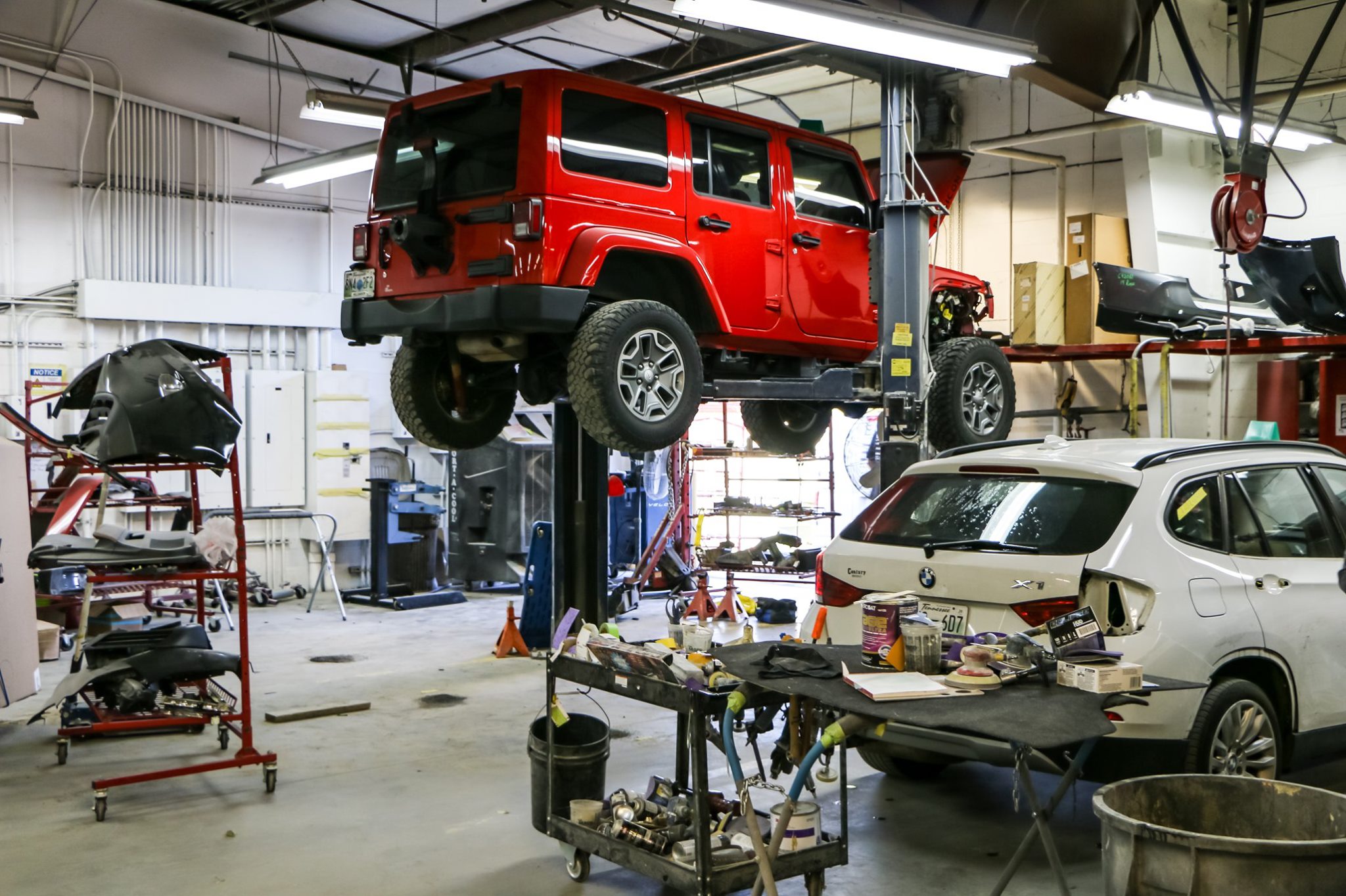 AJeep and BMW being repaired in the body shop of Cool Springs Collision Center