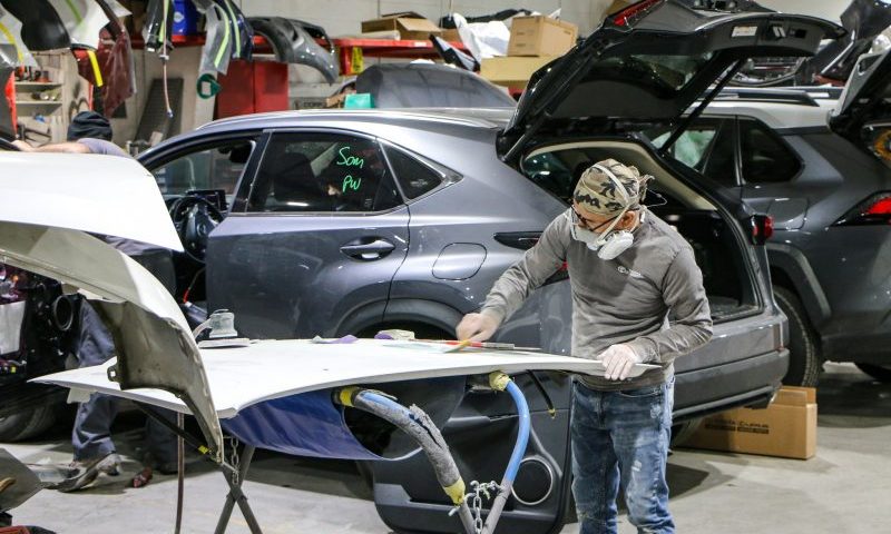 A professional body shop working repairing a hood at Cool Springs Collision Center