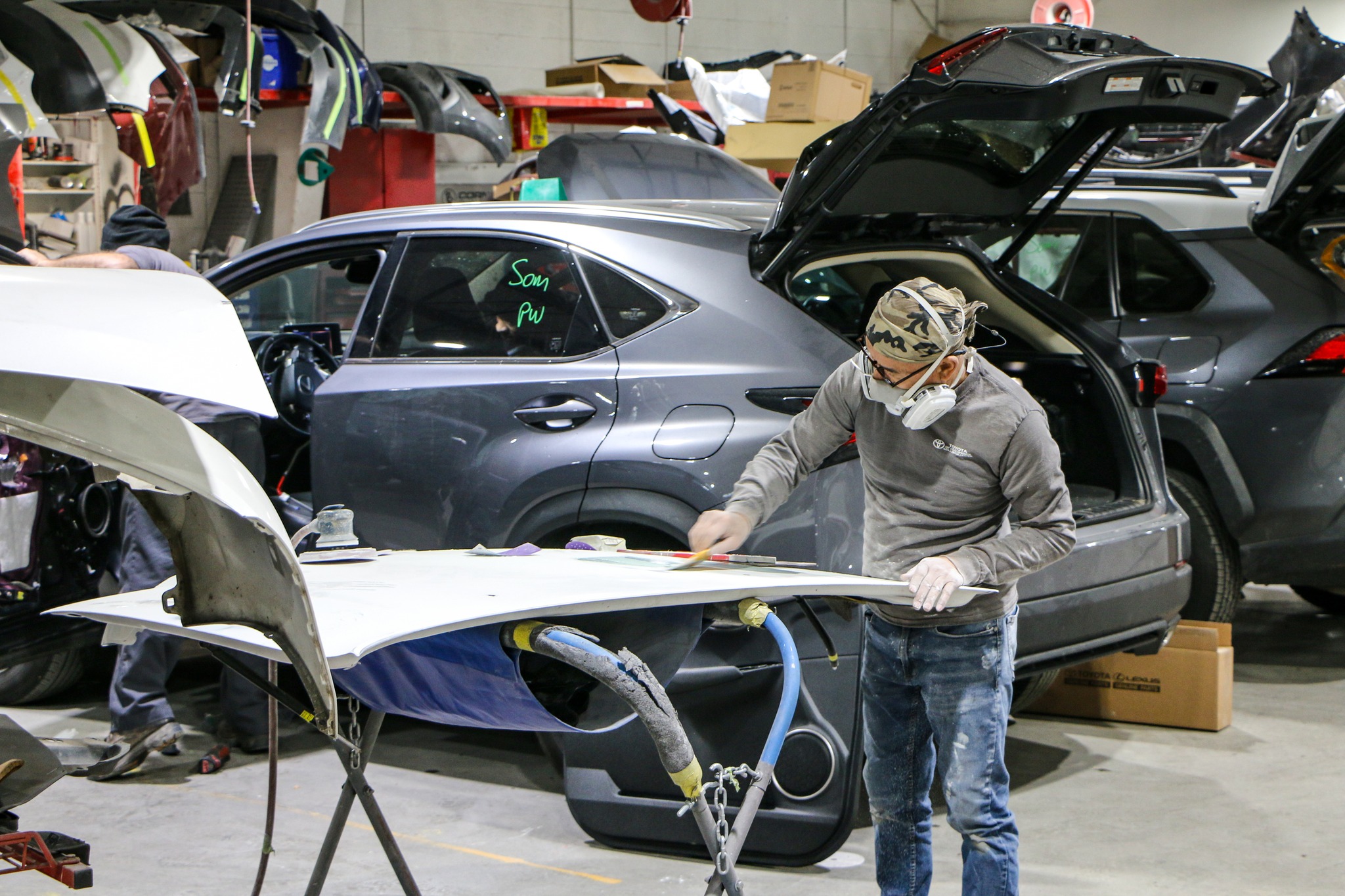 Man sanding and repairing a hood at Cool Springs Collision Center